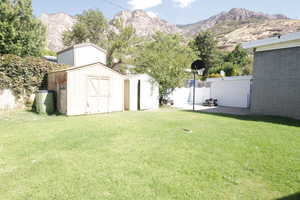 View of yard featuring a mountain view and a storage shed