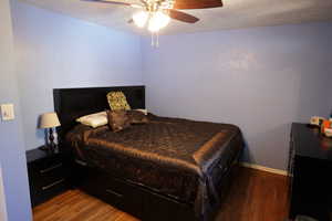 Bedroom featuring dark wood-type flooring and a ceiling fan
