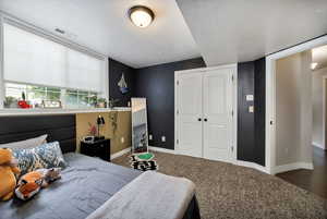 Bedroom 5 with carpet, a textured ceiling, and a closet