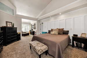 Master bedroom with light carpet, ornamental molding, a decorative wall, recessed lighting, and high vaulted ceiling
