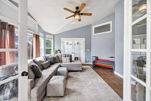 Living room featuring french doors, lofted ceiling, and ceiling fan