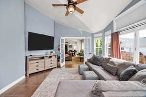 Living room featuring french doors, lofted ceiling, a ceiling fan, and dark tile patterned floors