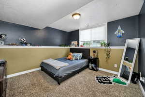 Bedroom 5 with a textured wall, carpet floors, and a textured ceiling