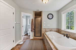 Master full bathroom featuring a garden tub, a double shower stall, and dark tile patterned floors