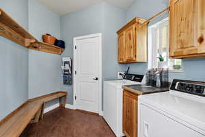Washroom featuring cabinet space and washer and dryer