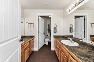 Full bathroom with two vanities, toilet, and bath/shower
