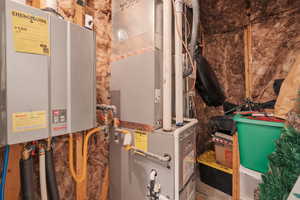 Utilities featuring Ranai tankless water heater and heating unit. There is room to finish it off with shelving for additional storage