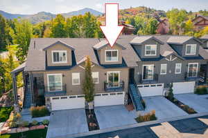 View of front facade with stairs, concrete driveway, and board and batten siding