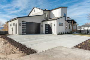 View of side of property with board and batten siding, driveway, and an attached garage