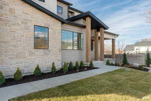 View of exterior entry featuring stone siding