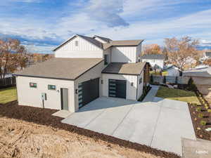 View of home's exterior with a shingled roof, board and batten siding, driveway, and an attached garage