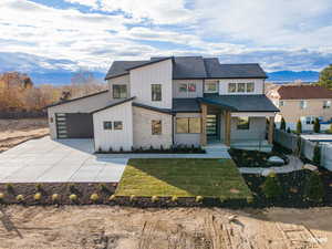 View of front of home with board and batten siding, roof with shingles, covered porch, a mountain view, and stone siding