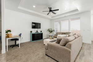 Living area featuring a raised ceiling, recessed lighting, ceiling fan, and an office area