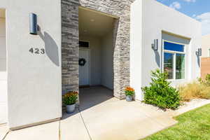 View of exterior entry with stone siding and stucco siding