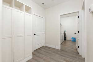 Hall with light wood-style floors and washing machine and clothes dryer