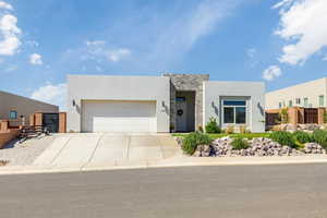 Contemporary house featuring stone siding, concrete driveway, an attached garage, and stucco siding