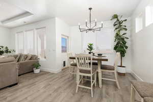 Dining space with light wood-type flooring and a chandelier