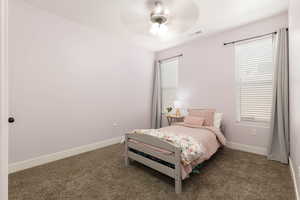 Carpeted bedroom featuring baseboards and a ceiling fan