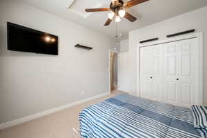 Bedroom featuring carpet, ceiling fan, and a closet