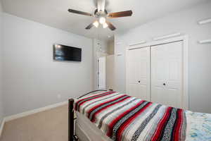 Bedroom featuring carpet flooring, a ceiling fan, and a closet