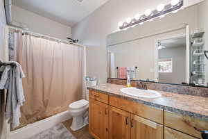 Bathroom with vanity, a shower with shower curtain, dark tile patterned flooring, and a ceiling fan