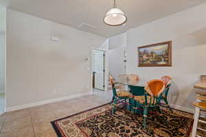 Dining area with light tile patterned floors and baseboards