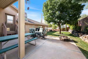 Fenced backyard featuring a patio area, a fire pit, and outdoor dining space