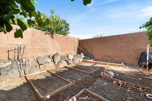 Fenced backyard featuring a garden