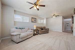 Living area with light carpet and a ceiling fan