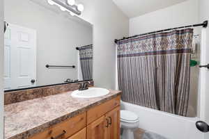Full bath featuring shower / tub combo with curtain, vanity, and light tile patterned flooring