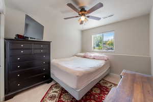 Bedroom featuring a ceiling fan and light carpet