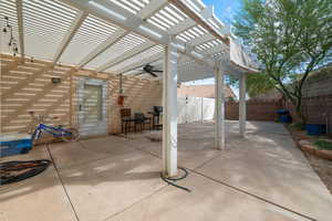 Fenced backyard featuring a patio, ceiling fan, a pergola, and area for grilling