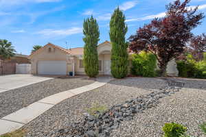 View of front of home with driveway, stucco siding, an attached garage, a tile roof, and a gate