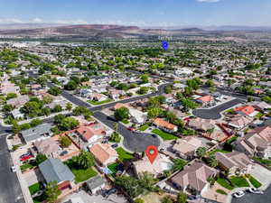 Aerial view of property and surrounding area with mountains and nearby suburban area