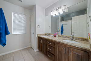 Bathroom with double vanity and baseboards