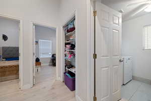 Corridor featuring washer / clothes dryer and light wood finished floors