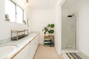 Full bath with double vanity and a shower stall