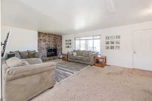 Carpeted living area featuring a fireplace and wood finished floors