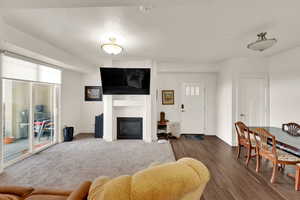 Living area featuring a glass covered fireplace and wood finished floors