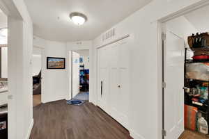 Corridor featuring dark wood finished floors and baseboards