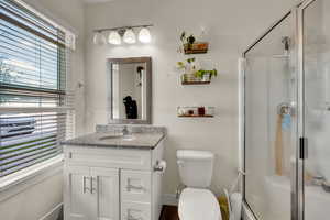 Bathroom with vanity, a shower stall, and dark wood-style floors