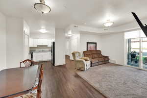 Living area with baseboards and dark wood-type flooring