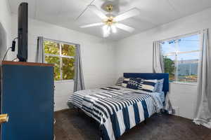 Bedroom featuring concrete block wall and ceiling fan