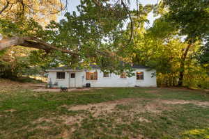 Back of property with a yard and roof with shingles