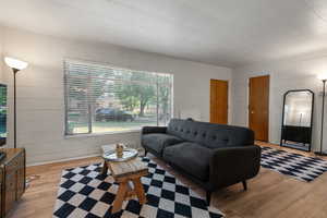 Living area with wood-type flooring and concrete block wall