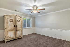 Unfurnished bedroom with crown molding, a textured ceiling, dark carpet, and ceiling fan