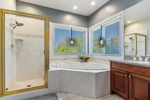 Bathroom with a shower stall, light tile patterned flooring, a garden tub, vanity, and recessed lighting