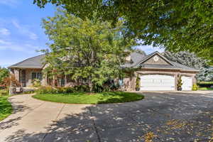 Obstructed view of property featuring concrete driveway, brick siding, a garage, covered porch, and a front lawn