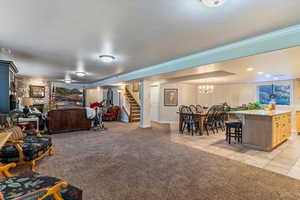 Living room featuring light colored carpet, stairway, light tile patterned floors, and ornamental molding