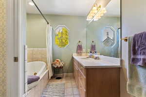 Bathroom featuring vanity, a whirlpool tub, and light tile patterned floors